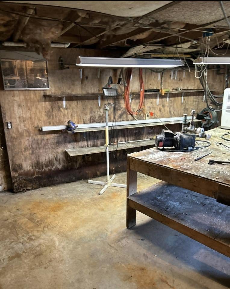 Basement workbench area after cleanout, with the ceiling opened