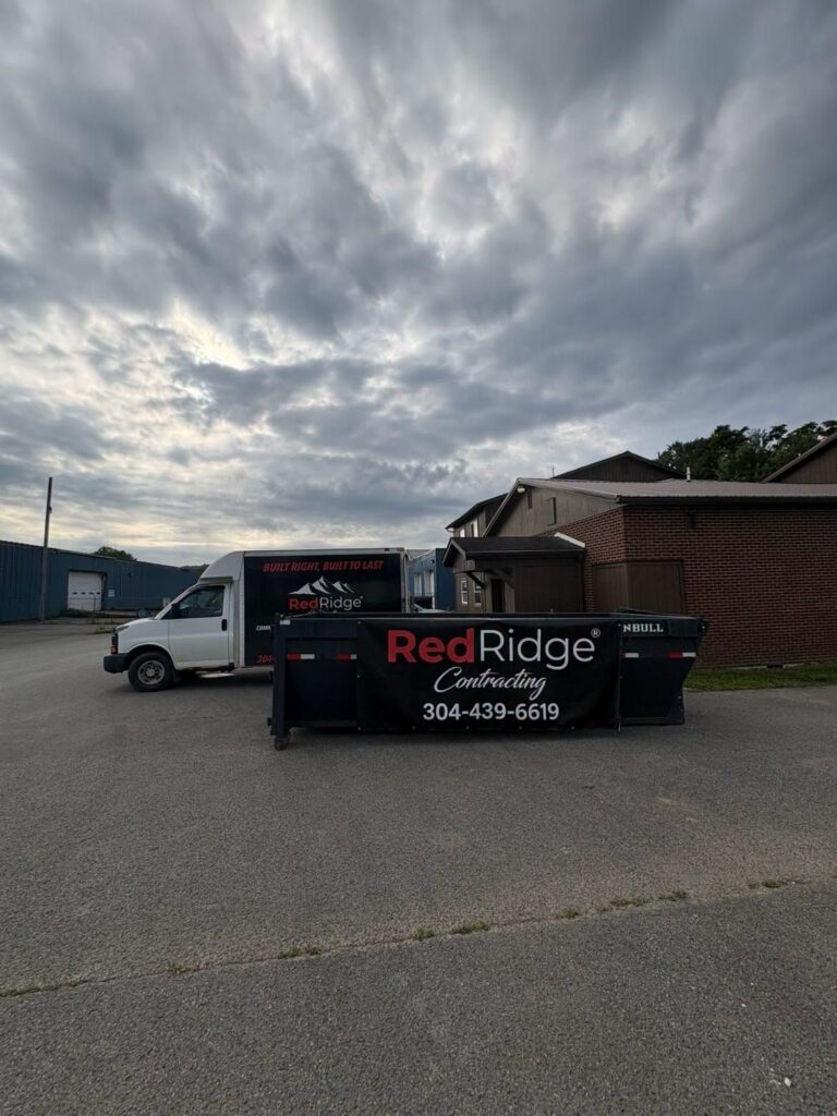 Red Ridge Contracting box truck and branded roll-off dumpster