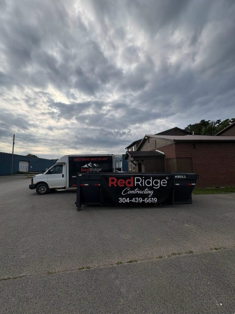Red Ridge Contracting box truck and branded roll-off dumpster