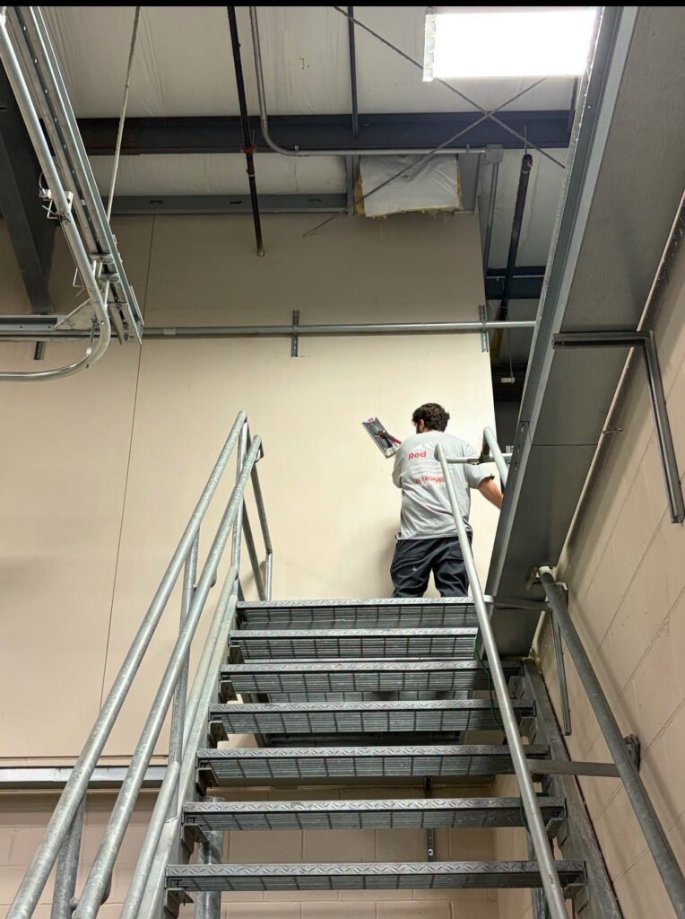 Red Ridge crew member finishing drywall in a commercial building