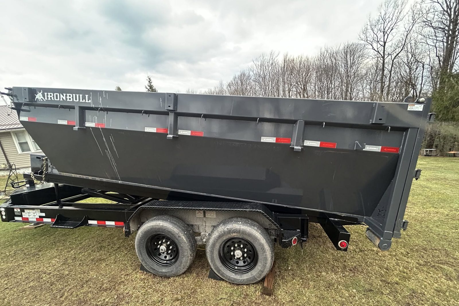 Dump trailer parked on grass at a job site