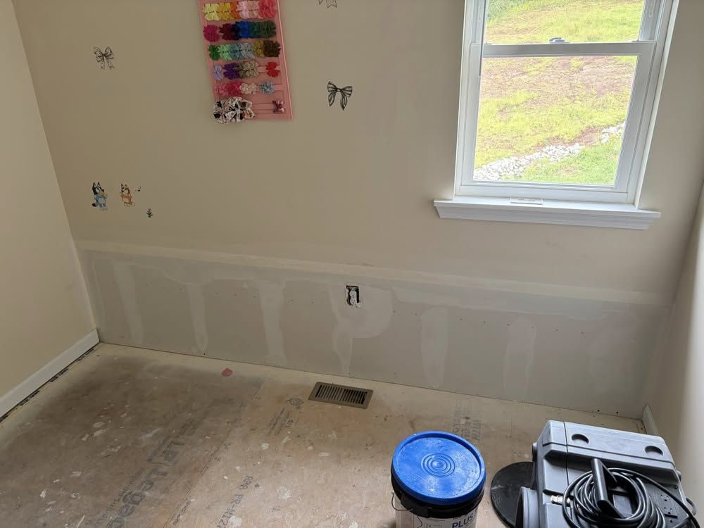 New lower drywall installed after water damage with drying equipment in place