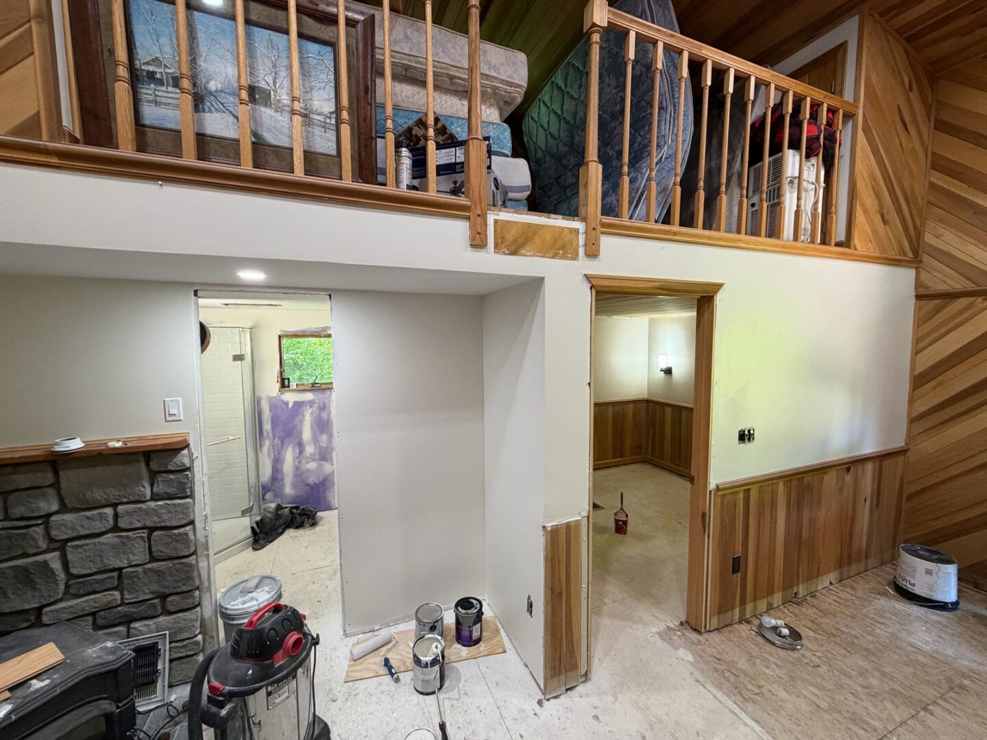 Two-level interior remodel in progress with stone and wood accents