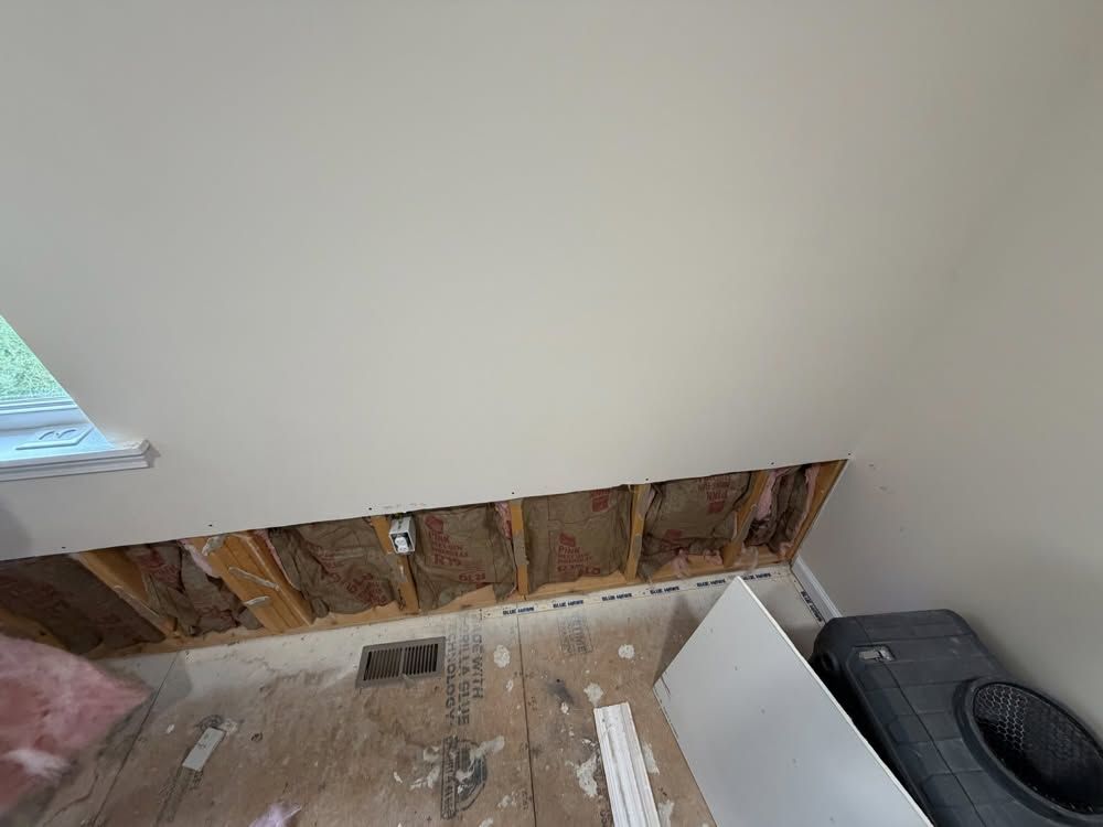 Flood cut with wet drywall and insulation removed during water damage cleanup in a West Virginia home