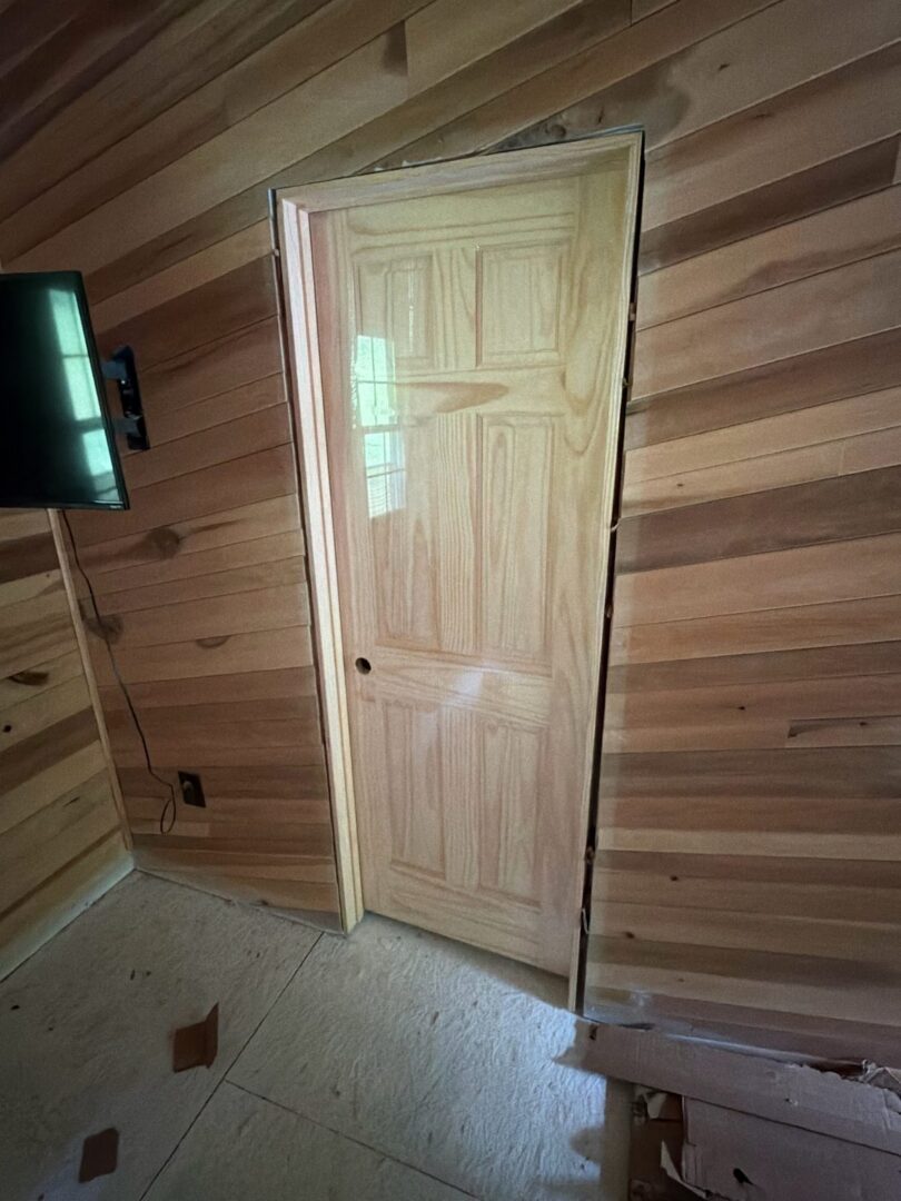 Interior wood-paneled wall with a new door installed