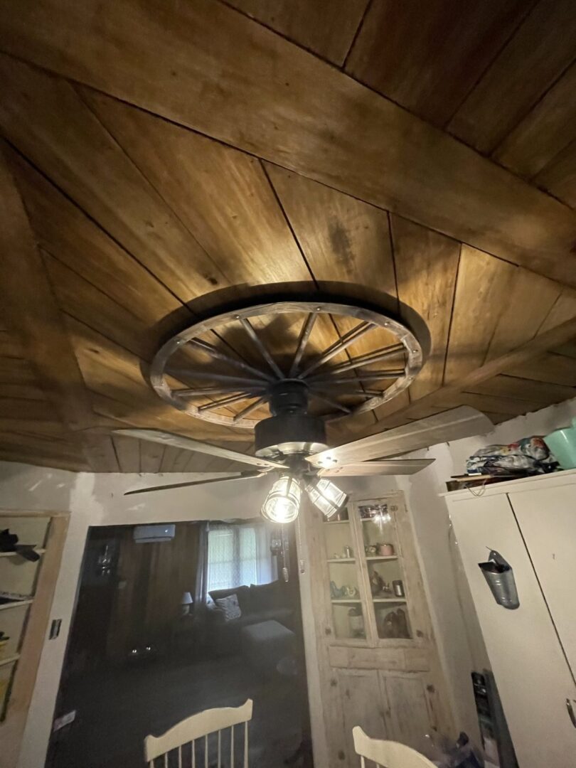 Remodeled room with a wood plank ceiling and ceiling fan